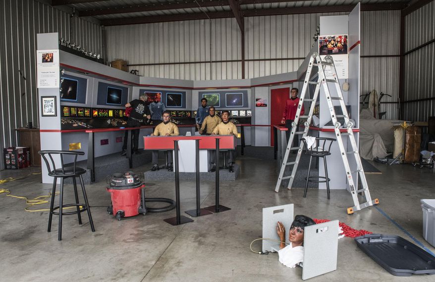 In this Saturday, March 25, 2017 photo, Steve Greenthal, left, and Chris Liebl work to set up their Star Trek wax figures in a hangar at the Fullerton Airport before donating them to the Hollywood Science Fiction Museum, in Fullerton, Calif. The figures are being restored for a five-year tour to raise money to get the museum a permanent home. (Nick Agro /The Orange County Register via AP)