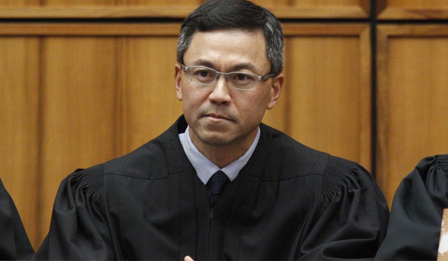 FILE  - This Dec. 2015 file photo shows U.S. District Judge Derrick Watson in Honolulu. Watson is hearing arguments Wednesday, March 29, 2017, in Honolulu, on whether to extend his temporary order blocking President Donald Trump’s revised travel ban. But even if Watson doesn’t put the ban on hold until the state’s lawsuit is resolved, his temporary block would remain until he rules otherwise.  (George Lee/The Star-Advertiser via AP, File)