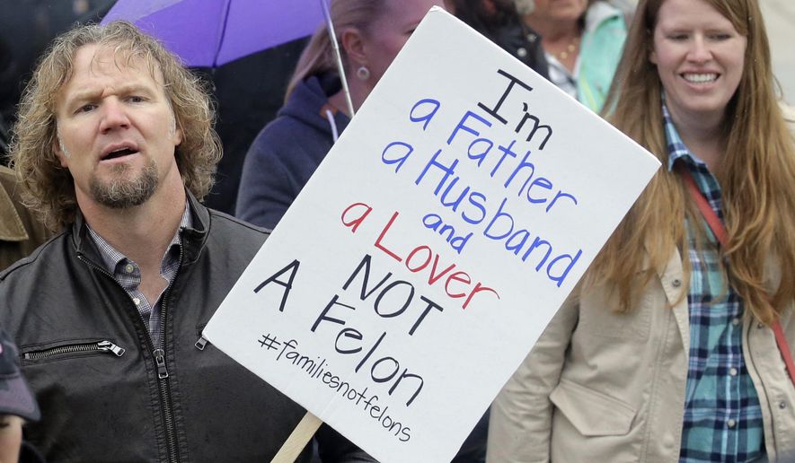 FILE - This Feb. 10, 2017, file photo, Kody Brown, left, from TV's reality show "Sister Wives," marches during a protest at the state Capitol, in Salt Lake City. Gov. Gary Herbert has signed into law a measure that hardens Utah's polygamy law by adding harsher penalties for polygamists convicted of other crimes such as domestic abuse. Polygamists opposed the bill, saying it is unconstitutional and unfairly targets their families. They say it will discourage people from reporting crimes like fraud or abuse. (AP Photo/Rick Bowmer, File)