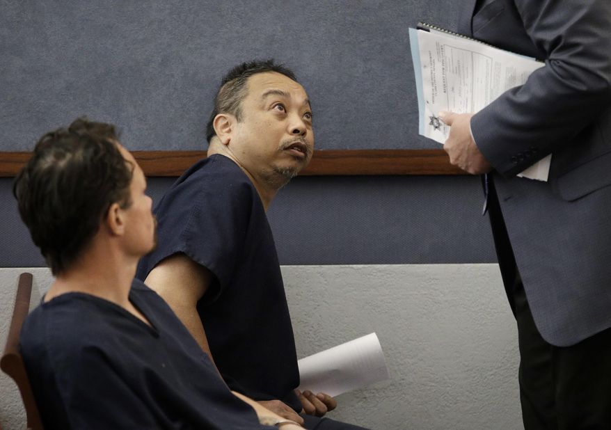 Rolando Cardenas, center, speaks with an attorney after appearing in court, Wednesday, March 29, 2017, in Las Vegas. Cardenas has been charged with killing one passenger and wounding another on a double-decker bus last weekend on the Las Vegas Strip. (AP Photo/John Locher)