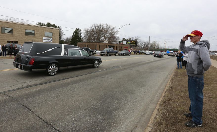 People line alongside Schofield Avenue to pay respect and solute as detective Jason Weiland procession moved through Wednesday, March 29, 2017, in Schofield, Wisc. Thousands of mourners turned out to say goodbye to a Wisconsin police detective killed in the line of duty along with three others in northern Wisconsin. (T'xer Zhon Kha/The Post-Crescent via AP)