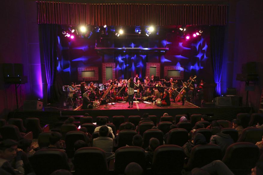 In this Tuesday, Feb. 14, 2017 photo, orchestra conductor Negin Khpolwak, 20, center, rehearses with Afghanistan’s first all-female symphony in Kabul. They are trying to change attitudes in a deeply conservative country where many see music as immoral, especially for women. (AP Photo/Rahmat Gul)