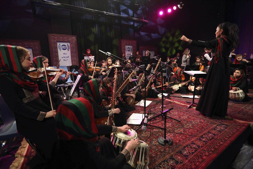 In this Wednesday, Feb. 15, 2017 photo, orchestra conductor Zarifa Adiba, 18, performs during a concert in Kabul. Afghanistan’s first all-female symphony is trying to change attitudes in a deeply conservative country where many see music as immoral, especially for women. (AP Photo/Rahmat Gul)