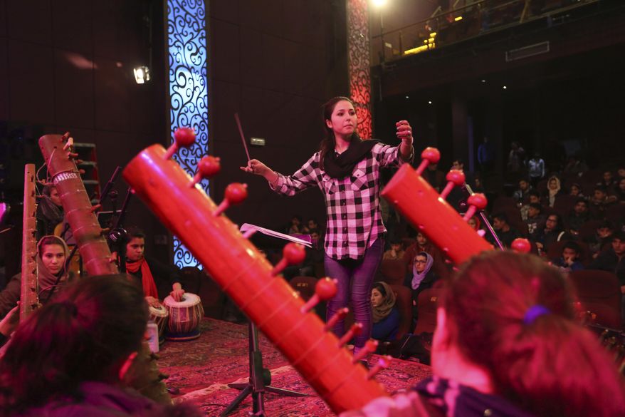 In this Tuesday, Feb. 14, 2017 photo, orchestra conductor Negin Khpolwak, 20, center, rehearses with Afghanistan’s first all-female symphony in Kabul. They are trying to change attitudes in a deeply conservative country where many see music as immoral, especially for women. (AP Photo/Rahmat Gul)