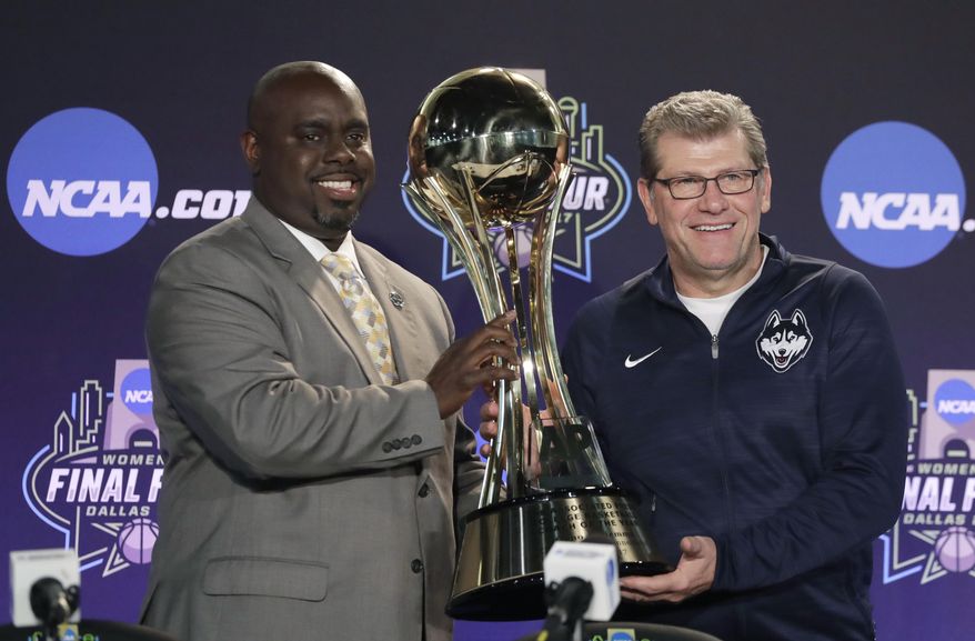 Connecticut head coach Geno Auriemma, right, is awarded his trophy by the Associated Press' Everett H. Jefferson II, left, after he was named The Associated Press' women's college basketball Coach of the Year at the women's NCAA Final Four college basketball tournament, Thursday, March 30, 2017, in Dallas. (AP Photo/Eric Gay)