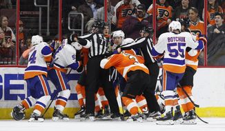 A scrum breaks out between the New York Islanders and the Philadelphia Flyers after the horn blew to end the second period of an NHL hockey game, Thursday, March 30, 2017, in Philadelphia. (AP Photo/Chris Szagola)