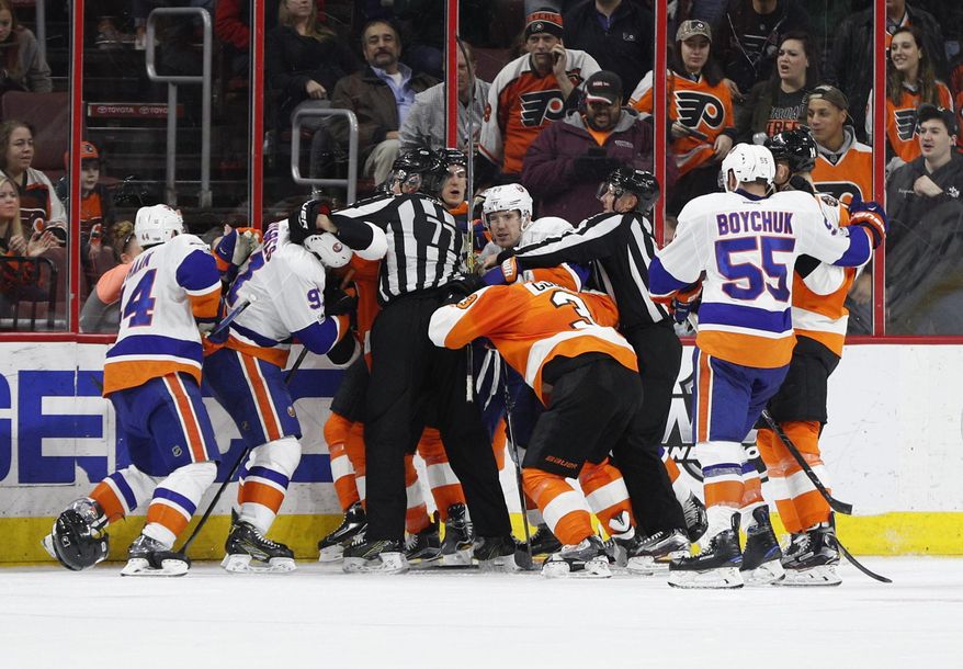 A scrum breaks out between the New York Islanders and the Philadelphia Flyers after the horn blew to end the second period of an NHL hockey game, Thursday, March 30, 2017, in Philadelphia. (AP Photo/Chris Szagola)