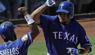 FILE - In this March 19, 2017, file photo, Texas Rangers&#39; Carlos Gomez celebrates with Delino DeShields after Gomez hit a two-run home run during the third inning of a spring training baseball game against the Seattle Mariners, in Surprise, Ariz. Gomez would play any position for the Rangers. The outfielder just wouldn’t want to play for another team right now. (AP Photo/Darron Cummings, File)