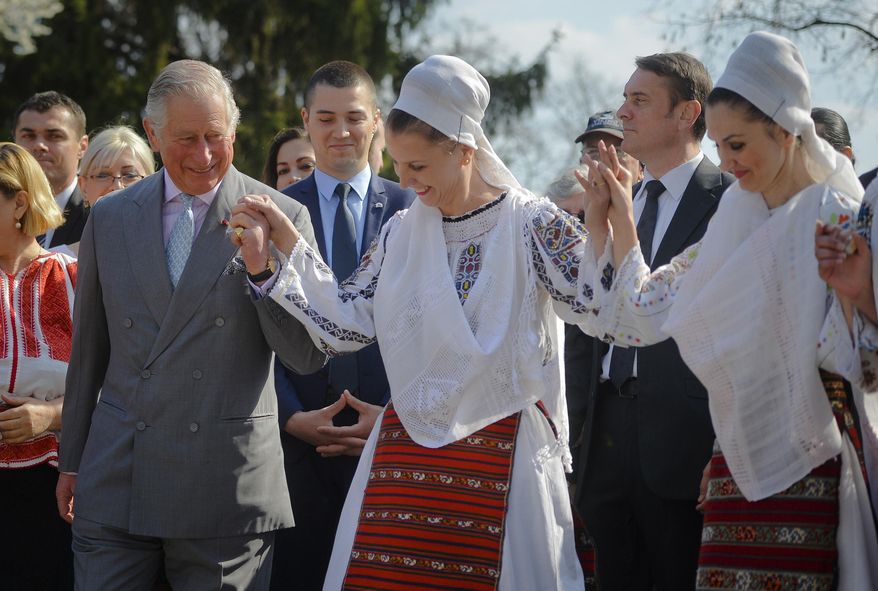 Britain&#39;s Prince Charles, left, joins a traditional folk dance in Bucharest, Romania, Thursday, March 30, 2017. Britain&#39;s Prince Charles toured the Village Museum during his visit to Romania, Italy and Austria, a trip seen as an effort to reassure European Union nations that Britain remains a close ally. (AP Photo/Andreea Alexandru)