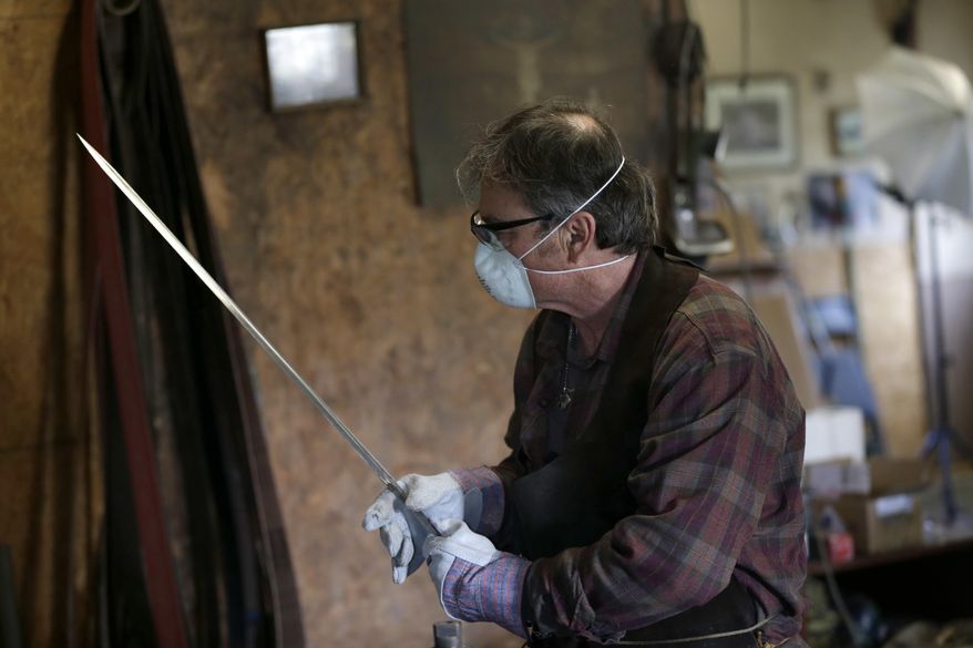 John Lundemo inspects an unfinished sword at his workshop in New Hampton, N.Y., Thursday, March 2, 2017. (AP Photo/Seth Wenig)