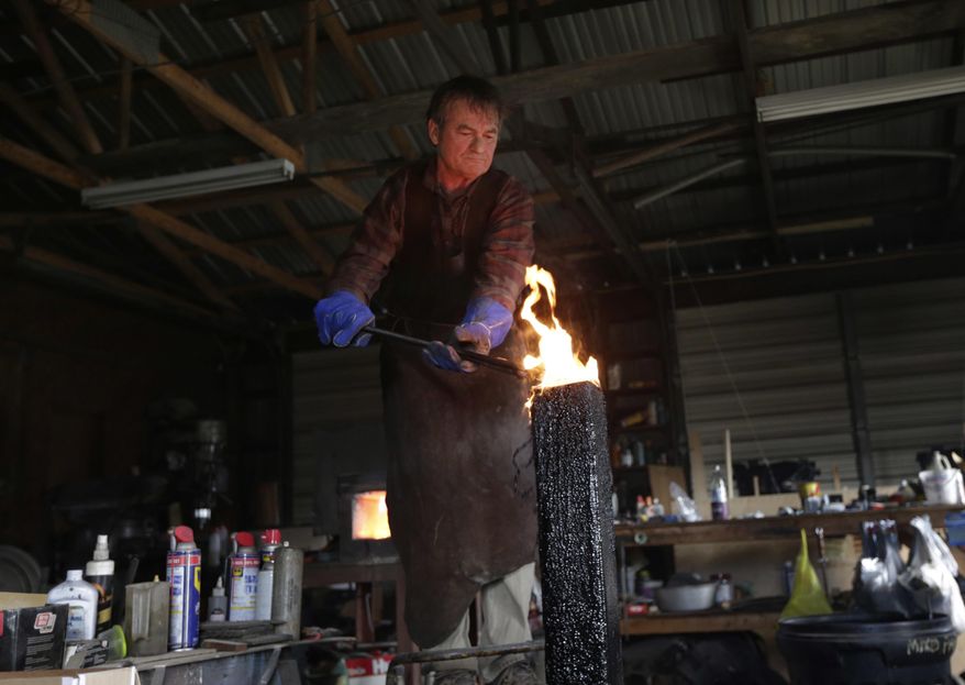 John Lundemo cools a sword just out of the forge at his workshop in New Hampton, N.Y., Thursday, March 2, 2017. (AP Photo/Seth Wenig)