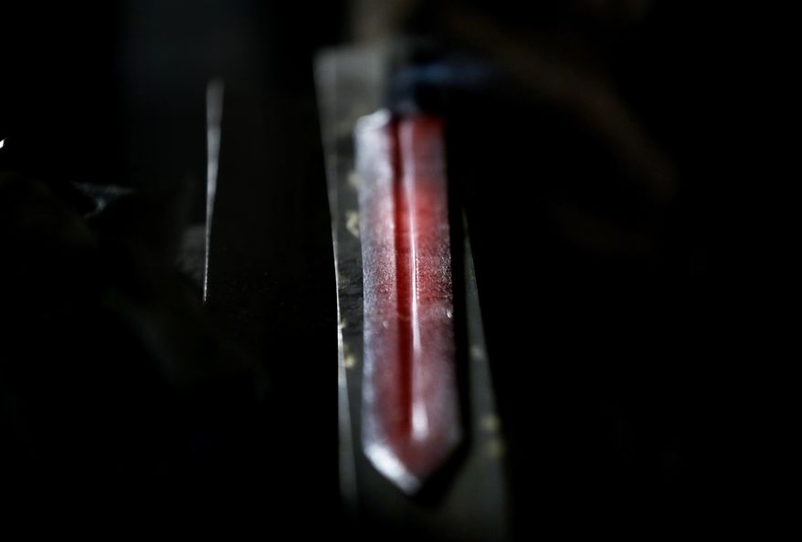 A sword glows red hot after being taken out of the forge at John Lundemo's workshop in New Hampton, N.Y., Thursday, March 2, 2017. (AP Photo/Seth Wenig)