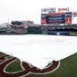A tarp covers the field as it is announced the Washington Nationals-Boston Red Sox exhibition baseball game was canceled at Nationals Park, Friday, March 31, 2017, in Washington. (AP Photo/Alex Brandon)