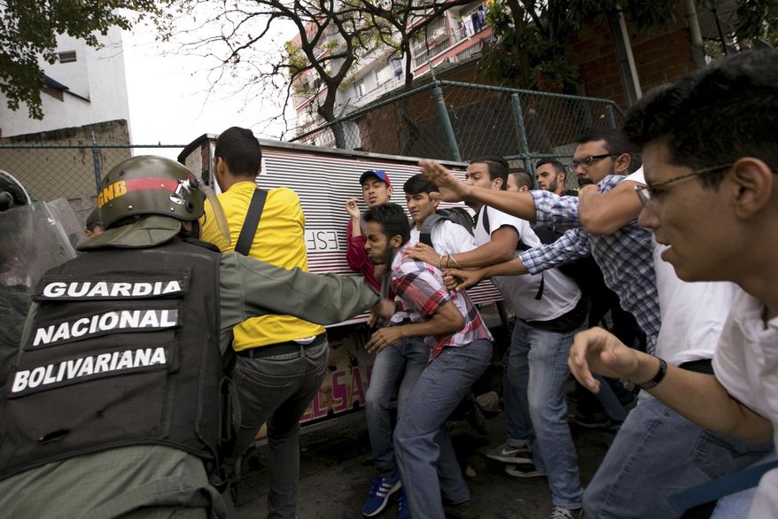 Venezuelan Bolivarian National guards officers are confronted by university students during a protest outside of the Supreme Court in Caracas, Venezuela, Friday, March 31, 2017. Venezuelans have been thrust into a new round of political turbulence after the government-stacked Supreme Court gutted congress of its last vestiges of power, drawing widespread condemnation from foreign governments and sparking protests in the capital. (AP Photo/Ariana Cubillos)
