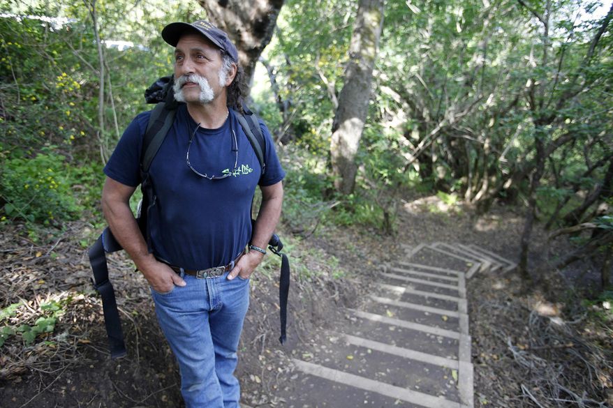 In this photo taken Thursday, March 30, 2017, Mark Siino prepares to head north on the new Pfeiffer Canyon trail that is open to residents traveling around the former Pfeiffer Canyon bridge in Big Sur, Calif. A Big Sur access foot trail has reconnected the two parts of the town that were divided after a bridge collapsed recently. Heavy rains this winter damaged the span on iconic Highway 1 beyond repair, splitting the touristy area in two and stranding more than 400 residents on one side. Visitors have been blocked from reaching part of the community known for its luxury spas, posh hotels and scenic retreats. (Vern Fisher/Monterey Herald via AP)