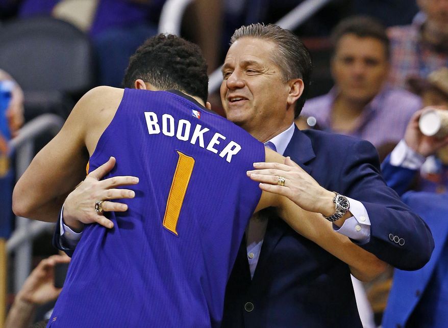 Phoenix Suns' Devin Booker (1) gives Kentucky college basketball coach John Calipari, right, a hug prior to an NBA basketball game against the Los Angeles Clippers, Thursday, March 30, 2017, in Phoenix. Suns' Booker played for Calipari at Kentucky. (AP Photo/Ross D. Franklin)