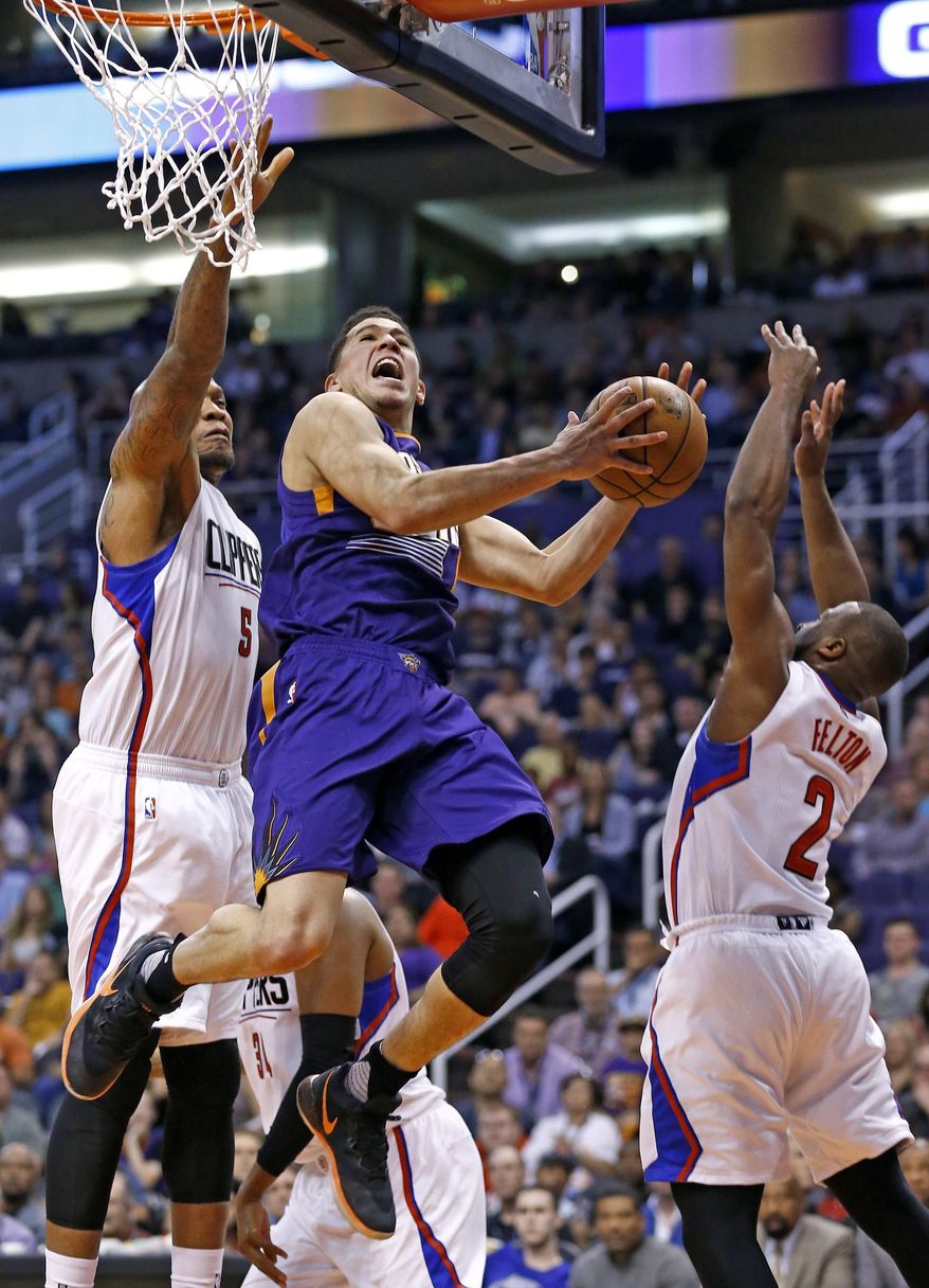 Phoenix Suns' Devin Booker, middle, drives past Los Angeles Clippers' Raymond Felton (2) and Marreese Speights during the second half of an NBA basketball game Thursday, March 30, 2017, in Phoenix. The Clippers defeated the Suns 124-118. (AP Photo/Ross D. Franklin)