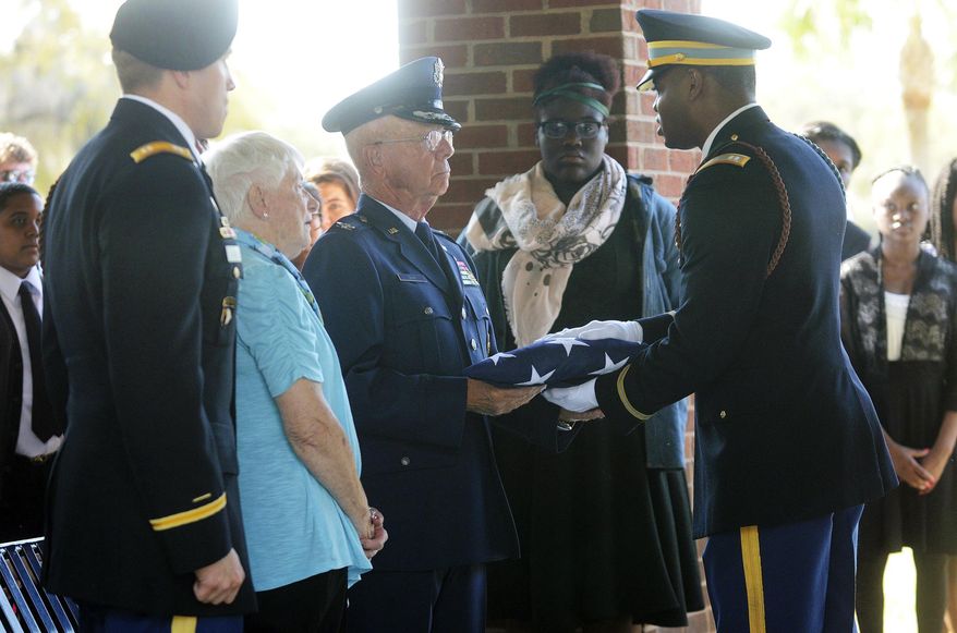 ADVANCE FOR USE SUNDAY, APRIL 2 - In this Thursday, March 30, 2017 photo, Perry Nuhn, of Callawassie Island, accepts the American flag that was draped on the casket containing the remains of his uncle, Capt. Albert Schlegel, at the Beaufort National Cemetery in Beaufort, S.C. Schlegel was killed in 1944 while serving as a pilot in the U.S. Army Air Force. Schlegel's remains were recently identified in France and his remains were brought back to the U.S. to be reinterred in Beaufort. (Delayna Earley/The Island Packet via AP)