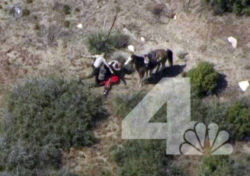 FILE - This April 9, 2015 file photo from video provided by KNBC-TV shows officers beating and kicking a man after a chase on horseback near Apple Valley, Calif. A jury on Thursday, March 30, 2017, convicted one former San Bernardino County sheriff's deputy of assaulting Francis Jared Pusok after the pursuit, but deadlocked on charges against two others. The jury found Charles Foster guilty of one count of assault by a public officer but split on ex-deputies Michael Phelps and Nicholas Downey. (AP Photo/KNBC-TV, File)