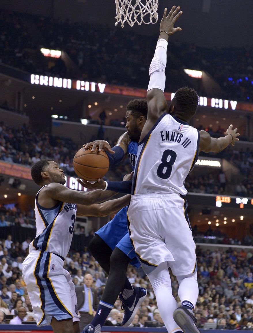 Dallas Mavericks guard Wesley Matthews, center, looks to pass between Memphis Grizzlies forward James Ennis (8) and guard Troy Daniels, left, in the first half of an NBA basketball game Friday, March 31, 2017, in Memphis, Tenn. (AP Photo/Brandon Dill)