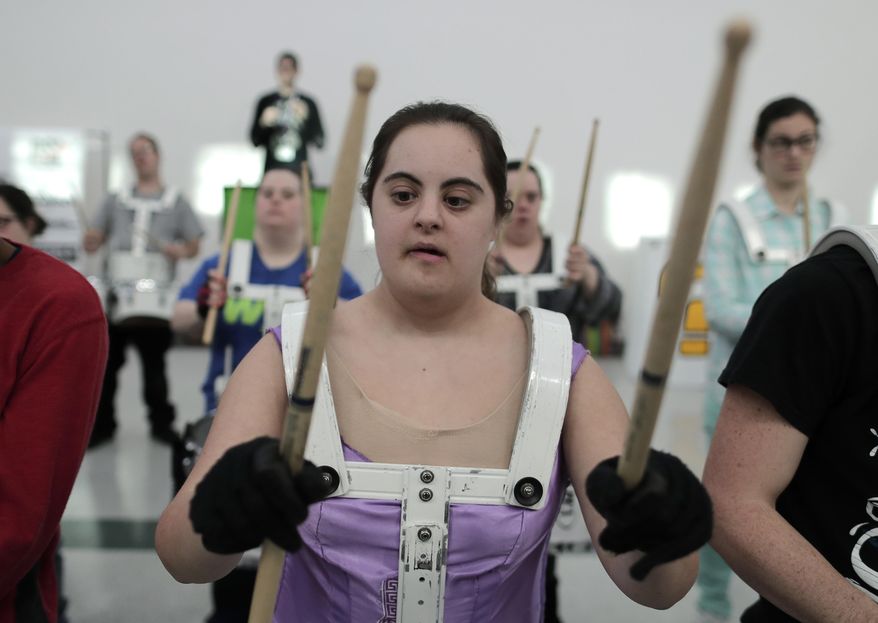 In this March 22, 2017, photo, a member of the FREE Players Drum Corps rehearses a routine with fellow percussionists in Old Bethpage, N.Y. The 65-member band is composed entirely of adults with intellectual and physical disabilities. They've performed at Disney World and marched in New York City's Columbus Day Parade. Now they’ve been invited to play an exhibition at the 2018 world championships in Indianapolis. (AP Photo/Julie Jacobson)