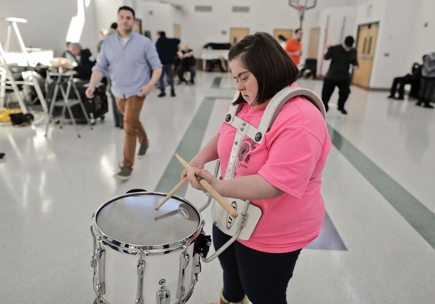 In this March 22, 2017, photo a member of the FREE Players Drum Corps practices her technique before a rehearsal in Old Bethpage, N.Y. The 65-member band is composed entirely of adults with intellectual and physical disabilities. They've performed at Disney World and marched in New York City's Columbus Day Parade. Now they’ve been invited to play an exhibition at the 2018 world championships in Indianapolis. (AP Photo/Julie Jacobson)