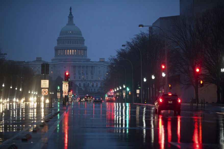 Capitol Hill is seen on the distance as rain falls on Pennsylvania Avenue in Washington, early Friday, March 31, 2017. (AP Photo/J. Scott Applewhite)