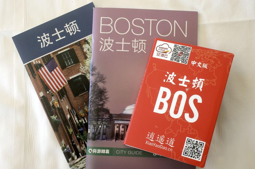 In this March 23, 2017, photo, an activities guide, left, a city guide, center, and a pop-up map, right, all with Chinese translations, are displayed in a guest room at the Sheraton Boston Hotel in Boston. The brochures are included in a welcoming kit that also contains creature comforts that many Chinese travelers expect, including an electric kettle, green tea, instant noodles, slippers, and a robe. In cities across the country, the American hospitality industry is stepping up efforts to make Chinese visitors feel more welcome. (AP Photo/Steven Senne)