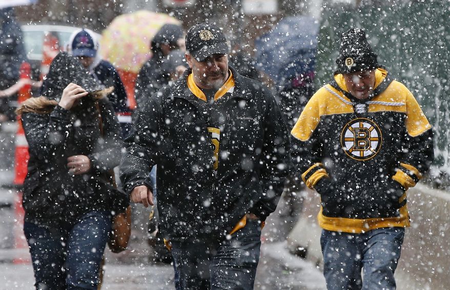 Boston Bruins fans walk to a game against the Florida Panthers at TD Garden as snow falls in Boston, Saturday, April 1, 2017. The April Fools Day storm that brought heavy, wet snow to much of northern New England is winding down, but not before causing crashes on highways across the region and leaving thousands without power. (AP Photo/Michael Dwyer)