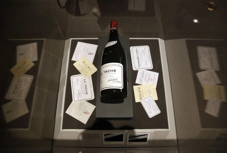 This March 29, 2017 photo shows a forged 1990 bottle of DRC La Tache wine that was sold to billionaire Bill Koch alongside assorted forged wine labels during a press preview of "Treasures on Trial: The Art and Science of Detecting Fakes" at the Winterthur Museum in Wilmington, Del. Under high magnification, experts determined that the label on the bottle was photocopied. The exhibition includes a broad range of objects that illustrate the ongoing battle pitting clever forgers and con men against equally determined art conservationists and historians. (AP Photo/Patrick Semansky)