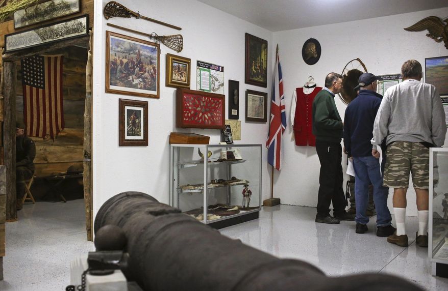 Visitors and museum volunteers walk through the exhibits which honor the centennial of WWI at the Michigan Military Heritage Museum in Grass Lake, Mich., on Nov. 4, 2016. (Emily Mesner/Jackson Citizen Patriot via AP)