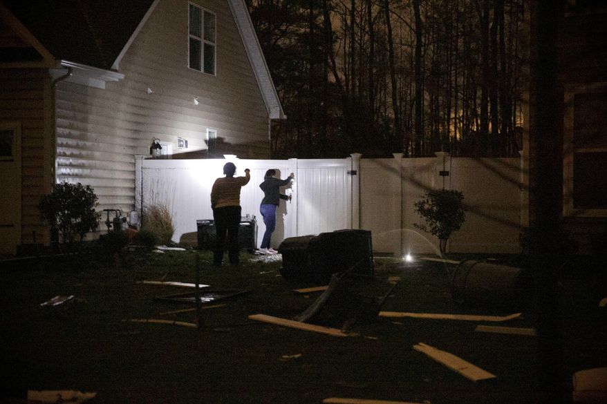 Jalee Saolds and her mom, Monica Thomas, check on Saolds' fence following a suspected tornado that hit the neighborhood off of Indian River Road and Eagle Cove Tail in Virginia Beach, Va., on Friday, March 31, 2017. Saolds was not home at the time the storm hit. The National Weather Service will not be able to confirm whether a tornado - or tornadoes - hit Hampton Roads until Saturday. (Kristen Zeis/The Virginian-Pilot via AP)