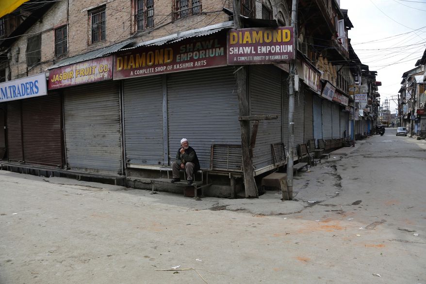 A Kashmiri man sits outside a closed shop during a strike in Srinagar, Indian controlled Kashmir, Sunday, April 2, 2017. Kashmiri separatists called for a strike Sunday to protest against the visit of Indian Prime Minister Narendra Modi to the disputed region. (AP Photo/Mukhtar Khan)