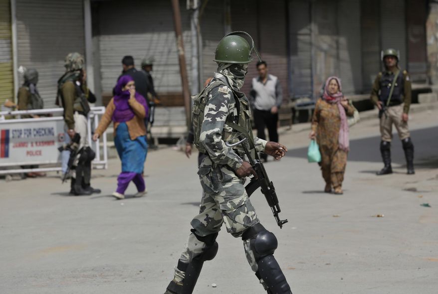 An Indian paramilitary soldier patrols at a closed market during a strike in Srinagar, Indian controlled Kashmir, Sunday, April 2, 2017. Kashmiri separatists called for a strike Sunday to protest against the visit of Indian Prime Minister Narendra Modi to the disputed region. (AP Photo/Mukhtar Khan)