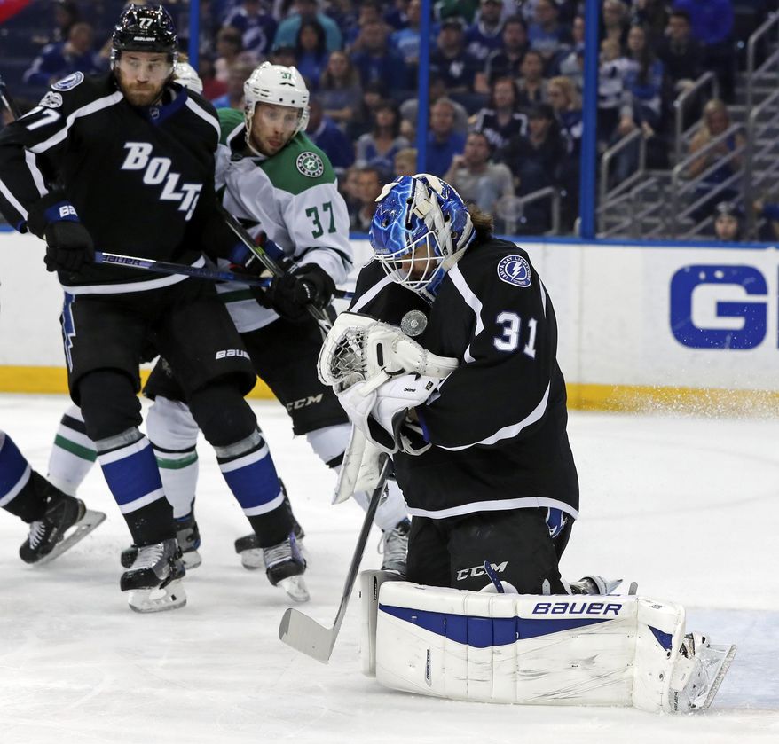 Tampa Bay Lightning goalie Peter Budaj, of Slovakia, makes a save as defenseman Victor Hedman, of Sweden, defends against Dallas Stars&#39; Justin Dowling during the first period of an NHL hockey game Sunday, April 2, 2017, in Tampa, Fla. (AP Photo/Mike Carlson)