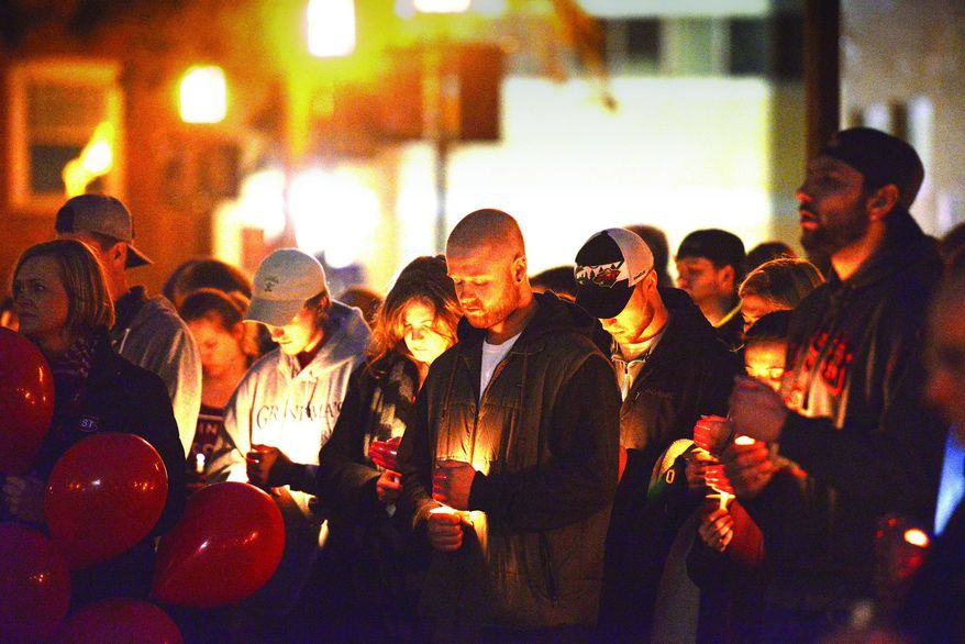 Friends, family and the St. Cloud State University, Minn., community gather to remember Jesse Dady at a candlelight vigil on Sunday, April 2, 2017, in St. Cloud, Minn. Authorities believe Dady fell from a railroad bridge into the Mississippi River where her body was found. (Ben Rodgers/St. Cloud Times via AP)