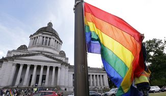 A state worker unfurls a rainbow flag in front of the Washington state Capitol to prepare it to be raised and then lowered to half-staff to mark last weekend&#39;s mass shooting at a central Florida nightclub, Wednesday, June 15, 2016, in Olympia, Wash. Gov. Jay Inslee and members from the LGBT community later raised the flag in honor of Gay Pride month, before it was lowered. A gunman wielding an assault-type rifle and a handgun opened fire inside Pulse, a crowded gay nightclub in Orlando, Florida, early Sunday, leaving at least 49 people dead in the worst mass shooting in modern U.S. history. (AP Photo/Elaine Thompson)