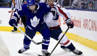 Washington Capitals right wing T.J. Oshie (77) and Toronto Maple Leafs defenseman Matt Hunwick (2) vie for control of the puck during the third period of an NHL hockey game Tuesday, April 4, 2017, in Toronto. (Frank Gunn/The Canadian Press via AP)