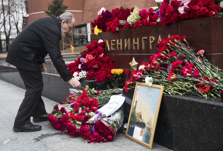 A man lays flowers in memory of victims killed by a bomb blast in a subway train in St. Petersburg, at the memorial stone with the word Leningrad (St. Petersburg) at the Tomb of Unknown Soldier, in front of the Kremlin wall in Moscow, Russia, Tuesday, April 4, 2017. A bomb blast tore through a subway train deep under Russia&#39;s second-largest city St. Petersburg Monday, killing several people and wounding many more in a chaotic scene that left victims sprawled on a smoky platform. (AP Photo/Pavel Golovkin)