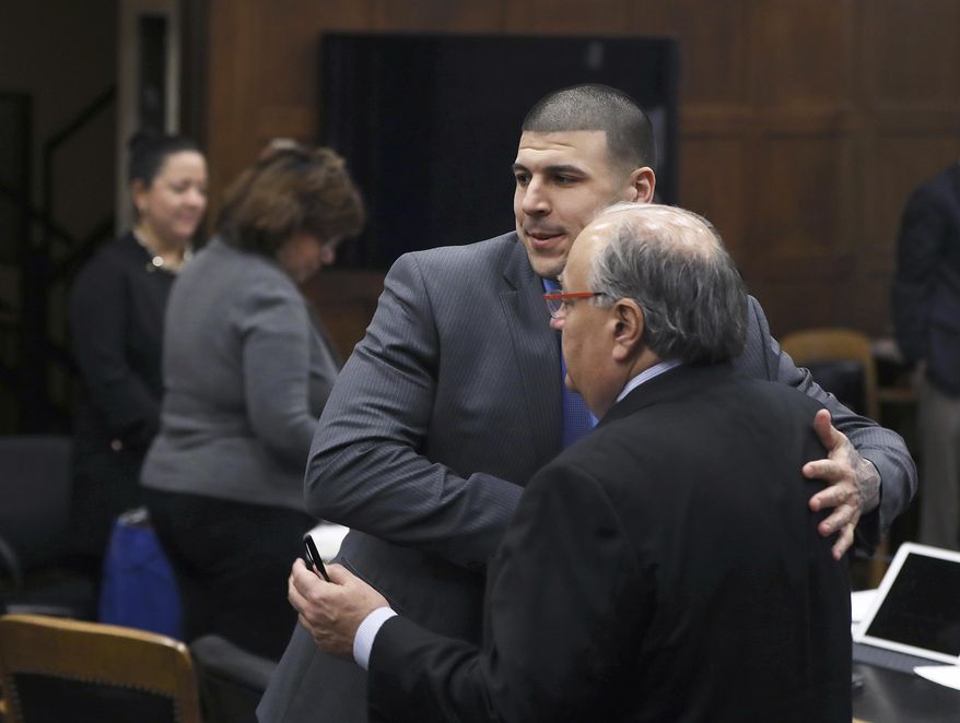 At the end of the shortened day, former New England Patriots tight end Aaron Hernandez hugs his defense attorneys, including George Leontire, in Suffolk Superior Court in Boston, Tuesday, April 4, 2017. Attorneys redacted evidence and went over the judge's proposed instructions to the jury. Hernandez is standing trial for the July 2012 killings of Daniel de Abreu and Safiro Furtado, who he encountered in a Boston nightclub. The former NFL player is already serving a life sentence in the 2013 killing of semi-professional football player Odin Lloyd. (Pat Greenhouse/The Boston Globe via AP, Pool)