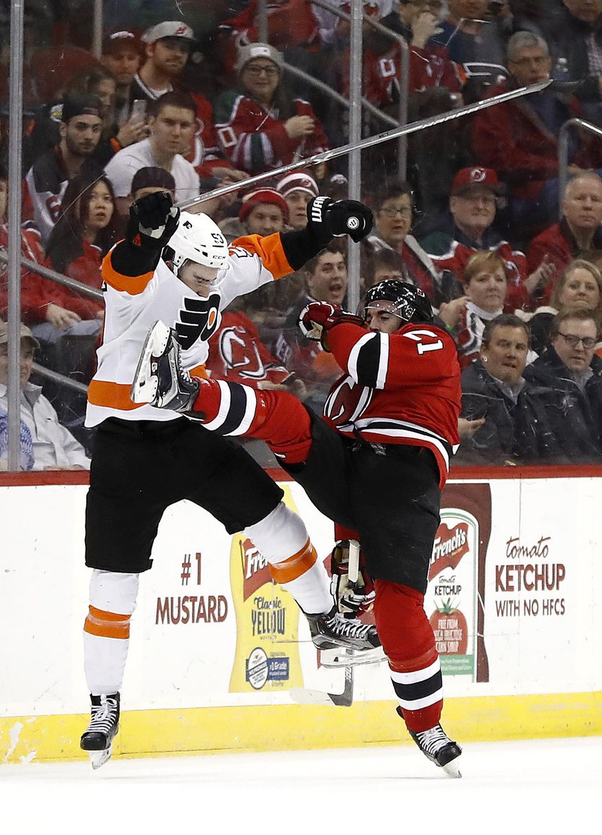 Philadelphia Flyers defenseman Shayne Gostisbehere, left, and New Jersey Devils right wing Kyle Palmieri collide while competing for the puck during the second period of an NHL hockey game, Tuesday, April 4, 2017, in Newark, N.J. (AP Photo/Julio Cortez)