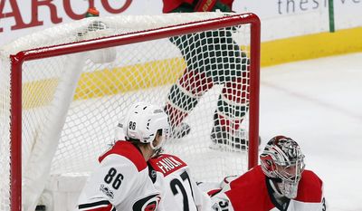 Minnesota Wild&#x27;s Nino Niederreiter, top, of Switzerland, celebrates a goal by Zach Parise off Carolina Hurricanes goalie Cam Ward, lower right, in the first period of an NHL hockey game Tuesday, April 4, 2017, in St. Paul, Minn. (AP Photo/Jim Mone)