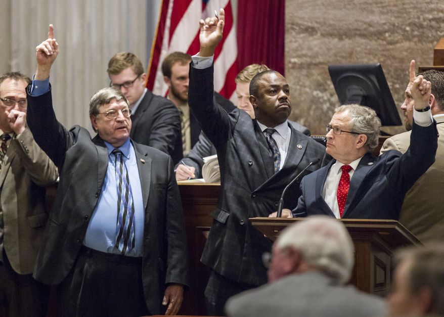 In this April 22, 2015, file photo, supporters of a bill to extend in-state tuition to students whose parents brought them into the country illegally signal their position on a motion from the well of the House chamber in Nashville, Tenn. From right are Reps. Mark White, R-Memphis; Joe Towns, D-Memphis, and Harry Brooks, R-Knoxville. A deeply conservative state, Tennessee voted overwhelmingly for President Donald Trump and his tough stance on immigration. And yet, Republican lawmakers are pushing a proposal that would allow public colleges to offer in-state tuition rates to students whose parents brought them into the country illegally. (AP Photo/Erik Schelzig, File)