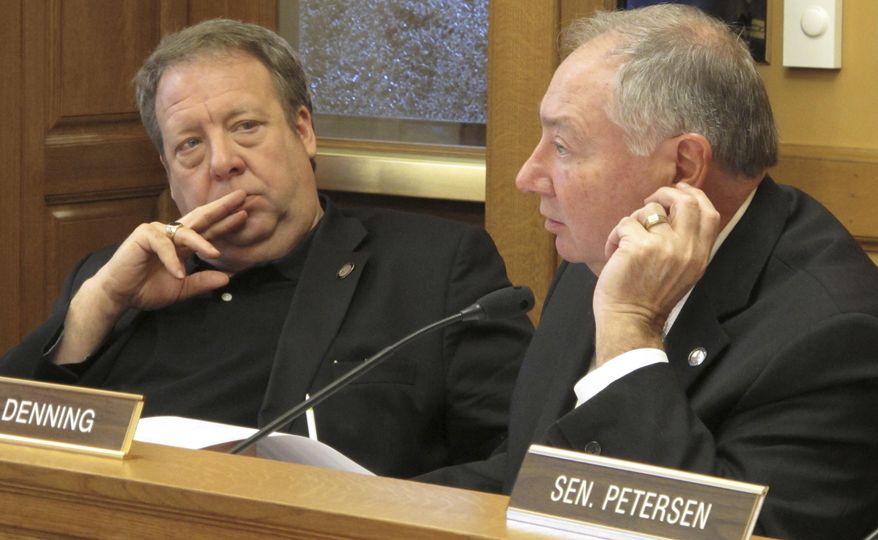 Kansas state Sen. Tom Holland, left, D-Baldwin City, listens as Senate Majority Leader Jim Denning, right, R-Overland Park, makes a point during a Senate Assessment and Taxation Committee meeting, Tuesday, April 4, 2017, at the Statehouse in Topeka, Kan. The committee has approved a bill that would move Kansas to a "flat" income tax with a single rate of 4.6 percent for all filers. (AP Photo/John Hanna)
