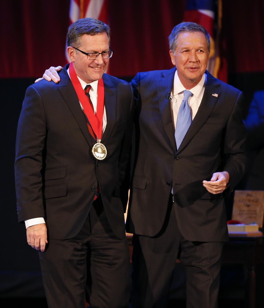 Ohio Gov. John Kasich, right, gives Judge Paul Herbert the Governor's Courage Award during the State of the State address at the Sandusky State Theatre, Tuesday, April 4, 2017, in Sandusky, Ohio. (AP Photo/Ron Schwane)