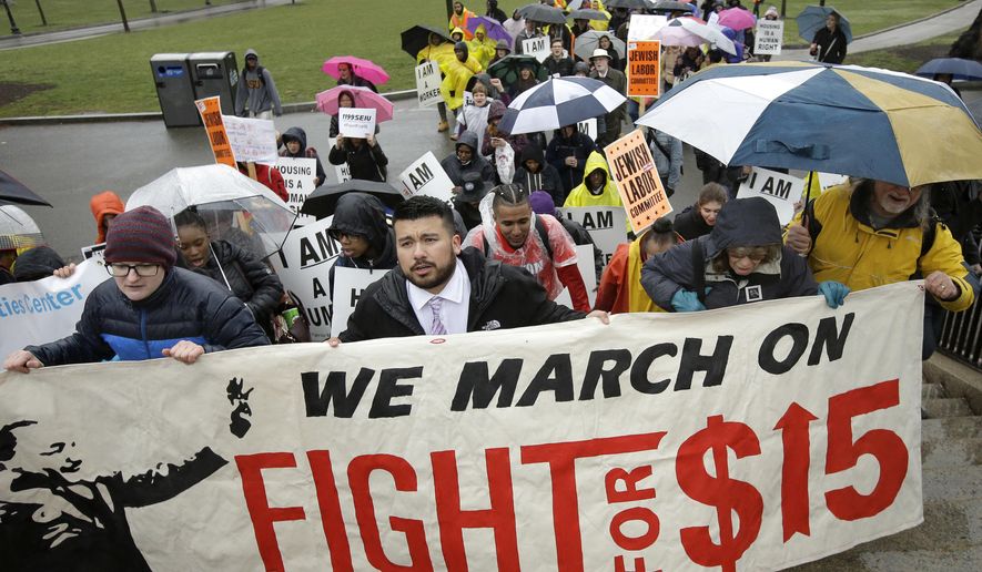Demonstrators carry signs and shout slogans during a protest Tuesday, April 4, 2017, in Boston, held to voice their concerns about racism and call attention to low wages. Tuesday was the 49th anniversary of the assassination of civil rights leader Martin Luther King Jr. (AP Photo/Steven Senne)