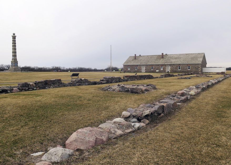 In this March 29, 2017 photo, ruins of a Civil War-era building at Fort Ridgely State Park sits near a remaining building and a monument by a golf course near Fairfax, Minn. A yearlong effort by a group to save the golf course at Fort Ridgely State Park from closure has shifted to the Legislature, where at least one lawmaker has concerns. The Minnesota Department of Natural Resources said last spring it can no longer afford to operate the course, but the local group of course supporters isn't giving up. (Brian Bakst/Minnesota Public Radio via AP)