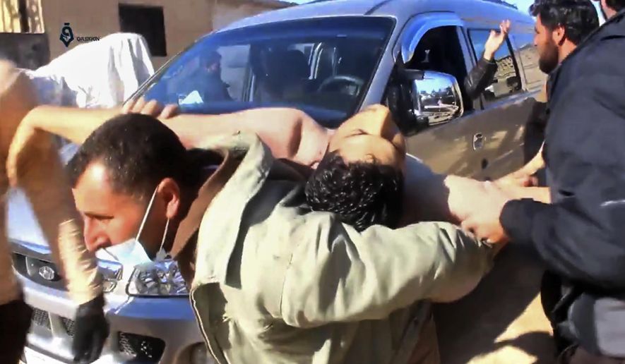This frame grab from video provided on Tuesday April 4, 2017, by Qasioun News Agency, that is consistent with independent AP reporting, shows a Syrian man carrying a man on his back who has suffered from a suspected chemical attack, in the town of Khan Sheikhoun, northern Idlib province, Syria. The suspected chemical attack killed dozens of people on Tuesday, Syrian opposition activists said, describing the attack as among the worst in the country&#x27;s six-year civil war. (Qasioun News Agency, via AP)