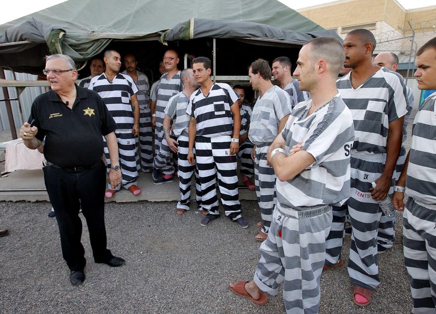 FILE - In this June 23, 2012, file photo, inmates gather next to Maricopa County Sheriff Joe Arpaio as he walks through a Maricopa County Sheriff's Office jail called "Tent City" in Phoenix. Newly elected Maricopa County Sheriff Paul Penzone announced Tuesday, April 4, 2017, that he will be closing the tent city jail in the coming months and relocating inmates to other jails. (AP Photo/Matt York, File)