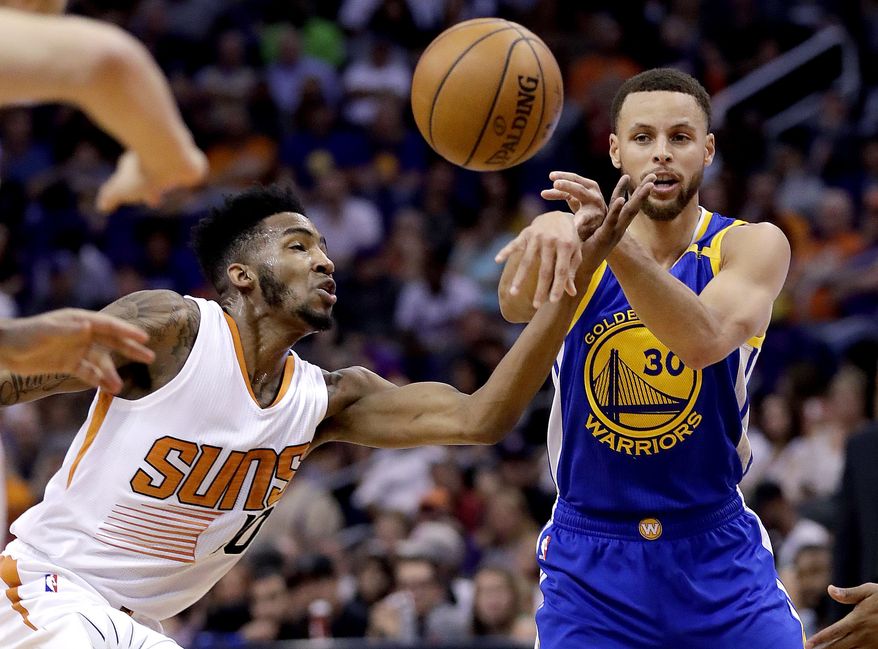 Golden State Warriors guard Stephen Curry (30) passes as Phoenix Suns forward Derrick Jones Jr. defends during the first half of an NBA basketball game, Wednesday, April 5, 2017, in Phoenix. (AP Photo/Matt York)